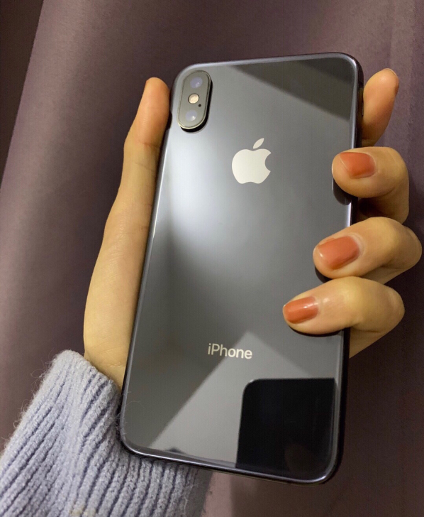 女生一手自用黑色iPhone X。