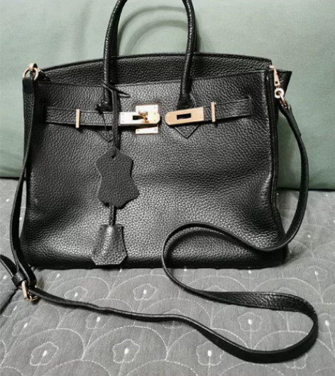 女式真皮提包一个，成色如图，边角轻微磨损，...